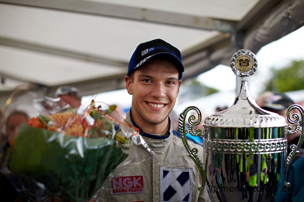 • Dennis Lind stolt med den store pokal og blomster efter sin flotte samlede 2.plads i Auto-G DTC-mesterskabet 2012 lige efter Jan Magnussen og foran John Nielsen samt Casper Elgaard.
(Foto: mementofoto.dk)